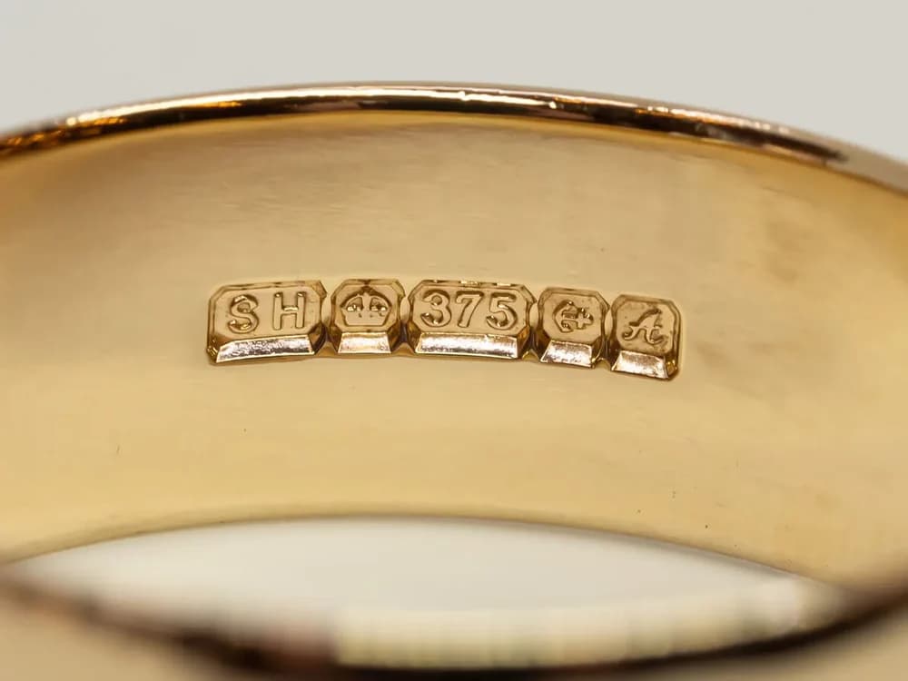 Close-up image of a 375 gold hallmark on a gold ring, indicating 9ct gold purity.