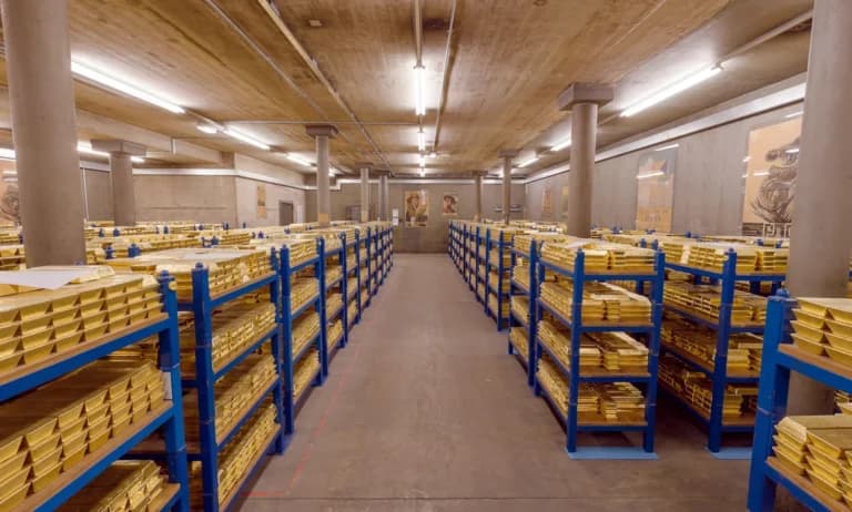 Interior of the Bank of England showing rows of stacked gold bars, representing the UK gold reserves securely stored in underground vaults.
