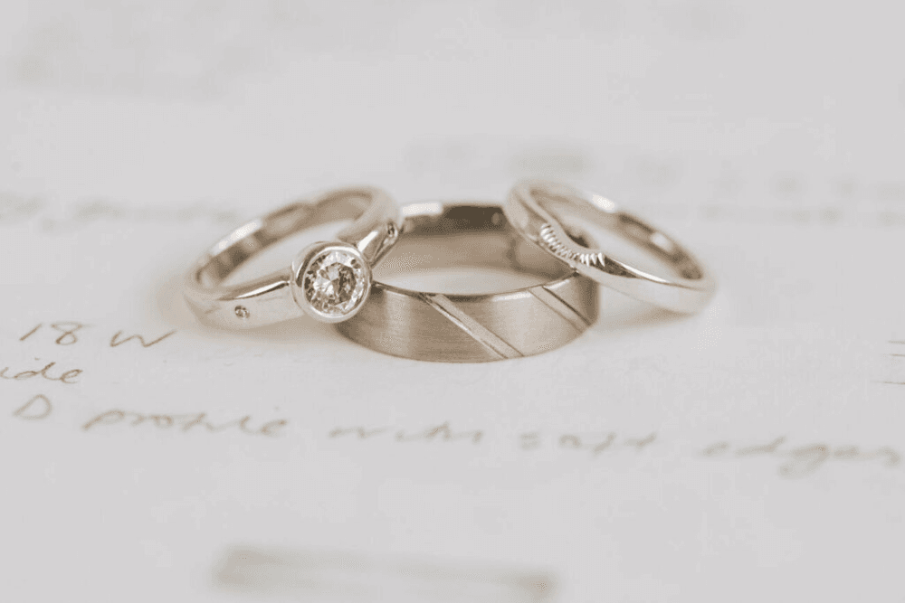 Three rings showing the colour difference between natural white gold and plated white gold.