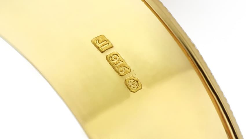 Close-up of a 22ct hallmark featuring a 916 stamp on gold jewellery, indicating 91.6% gold purity.