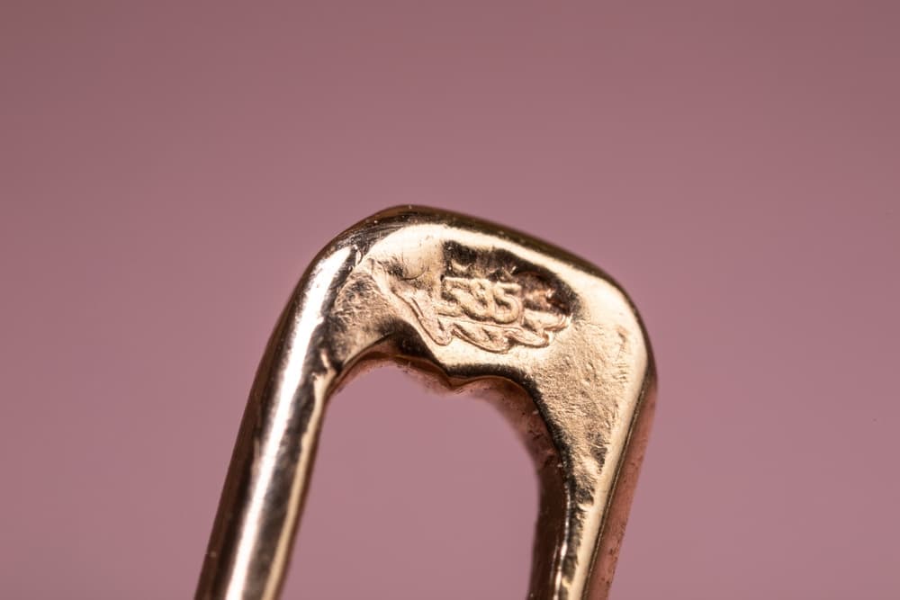 Close-up of 14ct gold hallmarks showing a 585 stamp on 14ct gold jewellery clasp.