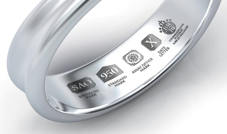 Close-up view of platinum hallmark symbols inside a ring, including the standard “950” fineness mark and additional UK assay office marks.