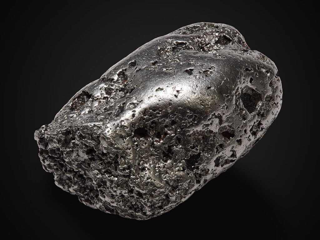 A raw platinum nugget with a silvery-grey metallic surface, showing platinum in its natural, unrefined form.