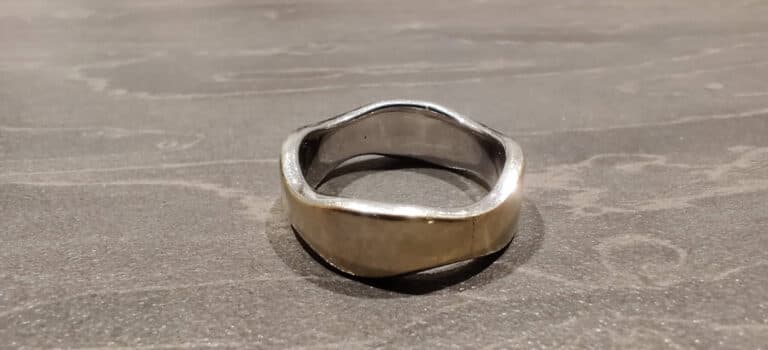 White gold ring with rhodium plating worn off — showing creamy yellow areas underneath, often mistaken for tarnish on white gold.