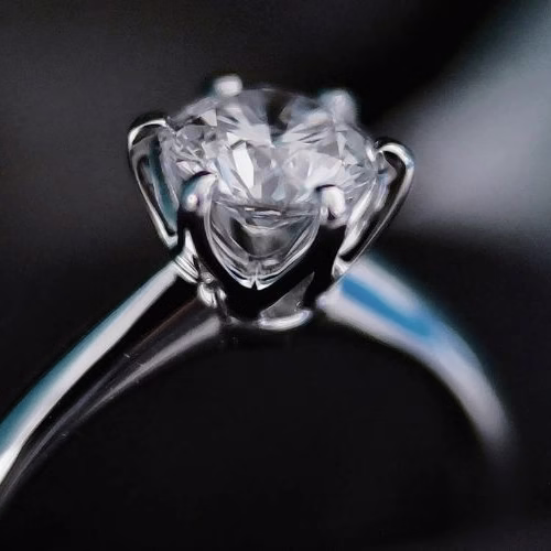 Close-up of a platinum engagement ring holding a diamond, showing what platinum is used for in fine jewellery.